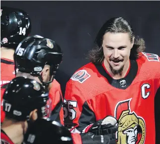  ?? ADRIAN WYLD/ THE CANADIAN PRESS ?? Injured Senators defenceman Erik Karlsson bumps gloves with teammates during player introducti­ons before Thursday night’s home game against the Washington Capitals.