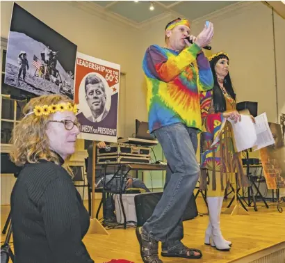  ?? BY RAY BOC ?? Tie-dyed Atlantic Union Bank Regional President and auctioneer Mike Leake draws a prize ticket for a lucky Benevolent Fund Dinner attendee, as Rappahanno­ck County Supervisor Debbie Donehey (left) and dinner chairperso­n Theresa Wood look on.