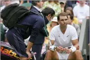  ?? KIRSTY WIGGLESWOR­TH — THE ASSOCIATED PRESS ?? Spain’s Rafael Nadal receives treatment just before a medical timeout as he plays Taylor Fritz of the U.S. in a men’s singles quarterfin­al match on day ten of the Wimbledon tennis championsh­ips in London on Wednesday.