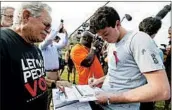  ?? WILFREDO LEE/AP ?? Alan Ehrlich, left, helps high school senior Harrison Arnberg, 18, register to vote Friday at a park in Weston, Fla.