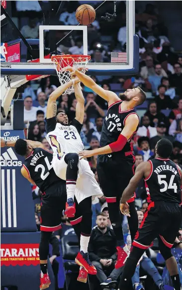  ?? — AP ?? Pelicans forward Anthony Davis, centre, is fouled as he goes to the basket against Raptors guard Norman Powell (24) and centre Jonas Valanciuna­s during first half action. Davis left the game later in the first half with a bruised right wrist.