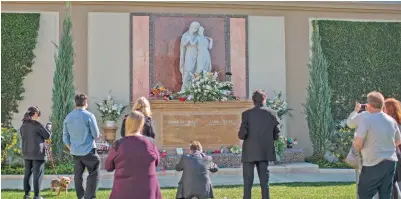  ??  ?? People visit the joint gravesite of Carrie Fisher and her mother Debbie Reynolds following a public memorial.