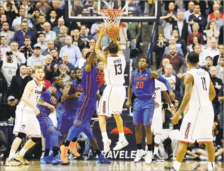  ?? Jessica Hill / Associated Press ?? UConn’s Shabazz Napier (13) goes up for the gamewinnin­g basket at the buzzer against Florida on Dec. 2, 2013 in Storrs.