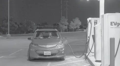  ?? PHILIP CHEUNG/THE NEW YORK TIMES ?? A driver charges their Chevrolet Bolt at an electric vehicle charging station in Victorvill­e, California.