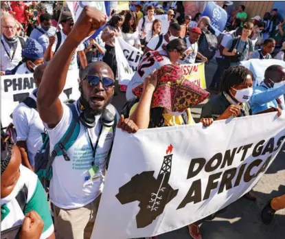  ?? JOSEPH EID / AFP ?? Climate activists brandish banners as they stage a protest on Nov 12 inside the Sharm El-Sheikh Internatio­nal Convention Centre during the COP27 climate conference.