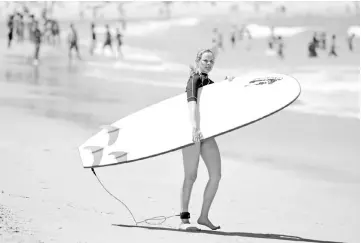  ??  ?? File photo shows a surfer heading into the sea on Bondi Beach in Sydney. — AFP photo