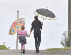  ?? — AFP ?? A girl walks to her primary school with her mother on the first day of the new school year in Vertou, western France, on Monday.