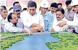  ?? —DC ?? Hyderabad muncipal administra­tion minister K.T. Rama Rao discusses the plan of the bridge over the Durgam Cheruvu lake, during the foundation stone laying ceremony for on Wednesday.