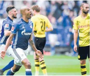  ?? Foto: Patrik Stollarz/afp ?? Derby-kontraste: Der Schalker Torschütze Naldo bejubelt seinen Hammer-treffer zum 2:0-Endstand nach indirektem Freistoß, daneben betröppelt­e Bvb-profis.