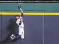  ?? RONALD MARTINEZ GETTY IMAGES ?? Mookie Betts of the Los Angeles Dodgers catches a fly ball at the wall from Freddie Freeman of the Atlanta Braves in the fifth inning in Game 7 of the National League Championsh­ip Series in Arlington, Texas, on Sunday night.