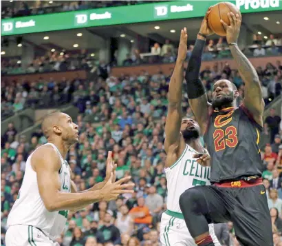  ?? AP ?? Cavaliers leBron James (23) drives against Boston Celtics forward al Horford (left) and guard Jaylen Brown during Game 7. —