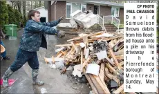  ?? CP PHOTO PAUL CHIASSON ?? David Samuelson throws debris from his flooded house onto a pile on his driveway in t h e Pierrefond­s borough of Montreal Sunday, May 14.