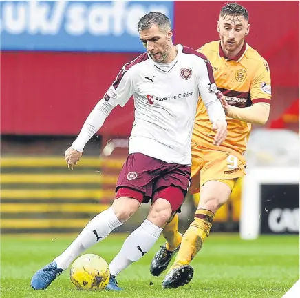  ??  ?? Hearts’ Aaron Hughes is shadowed by the Steelmen’s Louis Moult.