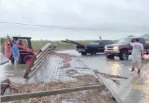  ??  ?? A dock that blocks the way is cleared from a flooded road in Mobile, Alabama, on Sunday, in this still image taken from a video obtained from social media. - Reuters