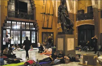  ?? Felipe Dana / Associated Press ?? Barcelona residents prepare to spend the night inside a school that was listed to be a polling station for the independen­ce vote set for Sunday. Police ordered all such locations vacated.