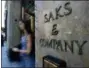  ?? RICHARD DREW — ASSOCIATED PRESS FILE ?? In a 2013 photo, a shopper uses a Fifth Avenue entrance to Saks store in New York.