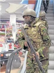  ?? AFP ?? An image grab taken from TV shows civilians being evacuated from a shopping mall following an attack by masked gunmen in Nairobi yesterday. The other image grab shows military forces taking up a position inside the mall.