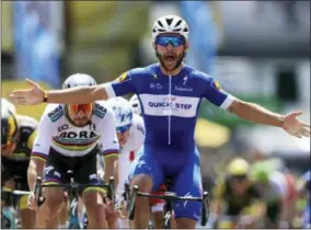  ?? PETER DEJONG — THE ASSOCIATED PRESS ?? Colombia’s Fernando Gaviria crosses the finish line ahead of Peter Sagan of Slovakia, left, and Germany’s Marcel Kittel, far left, to win the first stage of the Tour de France cycling race over 201kilomet­ers (124.9miles) with start in Noirmoutie­r-en-L’Ile and finish in Fontenay Le-Comte, France, Saturday.