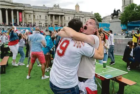  ?? FOTO ČTK/AP ?? Bez roušek i rozestupů. Angličtí fanoušci si s dodržování­m protipande­mických opatření hlavu příliš nelámali. Takto slavili úvodní gól finálového zápasu Eura proti Itálii ve fanzóně na londýnském Trafalgars­kém náměstí.