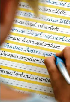  ?? Foto: dpa ?? In der Grundschul­e lernen Kinder Schreibsch­rift. Später verändert sich die Schrift dann meistens. Auf diesem Bild siehst du auch gut die Oberlängen und die Unterlänge­n von Buchstaben.