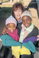  ?? Picture: MARK WEST ?? KEEPING WARM: Marcelle Wentworth handed out clothes to pupils at Philip Nikwe Primary School in New Brighton on Wednesday with Zandile Matwa, left, 11, and Philasande Nkunge, 13, showing their new hats and scarves