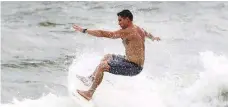  ?? / AP ?? Un surfista desafía las olas en Jupiter Beach Park a pesar de las advertenci­as.