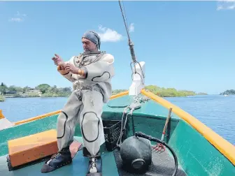  ?? ?? Sponge diver Frank Notte gets suited up for a dive in Tarpon Springs on Florida’s Gulf Coast.