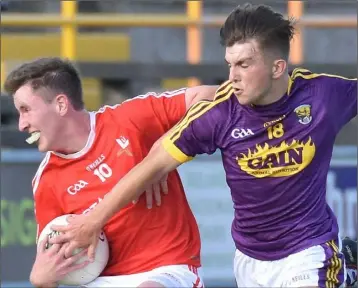  ??  ?? Diarmuid Kehoe challenges Gerry Garland who scored two of the four Louth goals.