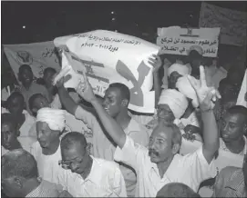  ?? REUTERS ?? Protesters hold banners and chant anti-Israel slogans as the Sudanese cabinet holds an emergency session over a factory blast, in Khartoum last week.