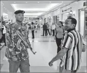  ?? Simon Maina AFP/Getty Images ?? A POLICE OFFICER patrols the Nairobi mall that was attacked by a team of four gunmen in 2013.