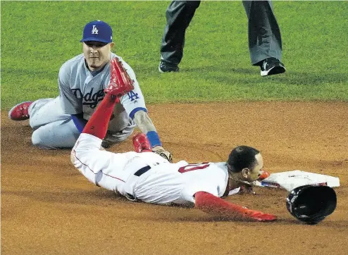  ?? ELISE AMENDOLA / THE ASSOCIATED PRESS ?? Mookie Betts of the Red Sox gets by Dodgers shortstop Manny Machado to steal second base in Game 1 of the World Series in Boston on Tuesday night. For a full report on the game, go to nationalpo­st.com.