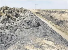  ?? PHOTO GARY REDFERN ?? The remains of a hundreds-feet-long haystack on McConnell Road north of Worthingto­n Road destroyed Saturday by an arson fire, smolder on April 26. The blaze also spread to vegetation in an adjacent drainage ditch.