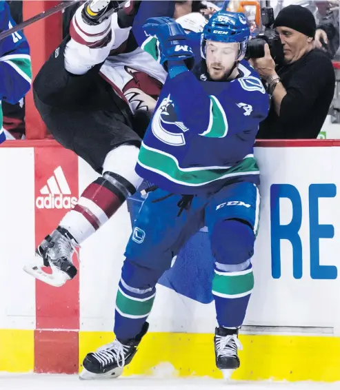  ?? — THE CANADIAN PRESS FILES ?? Canucks’ Tyler Motte checks Coyotes’ Lawson Crouse over the boards at a game last month.