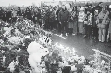  ?? ALEXANDER ZEMLIANICH­ENKO AP ?? People gather on Saturday to lay flowers and light candles next to the Crocus City Hall, on the western edge of Moscow. Russia’s top state investigat­ive agency says the death toll in the Moscow concert hall attack has risen to 133.