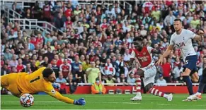  ?? ?? Three strikes, you’re out: bukayo saka scoring arsenal’s third goal past Hugo Lloris. — afp