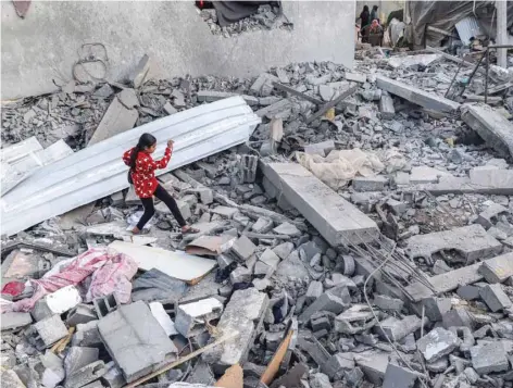  ?? — AFP ?? A girl walks through rubble in Rafah in the southern Gaza Strip.