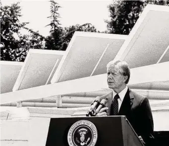  ?? Associated Press file photo ?? Then-President Jimmy Carter speaks against a backdrop of solar panels at the White House in June 1979. Carter had the panels installed in what became part of his legacy on energy and environmen­t. Shortly before he left office, the White House issued a report on global warming, whose advisement was later adopted in the Paris Agreement on climate change.