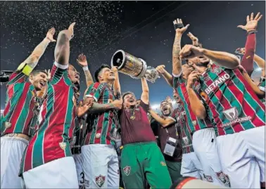  ?? ?? Fernando Diniz, técnico del Fluminense, levanta junto a sus jugadores el título de la Libertaddo­res 2023.