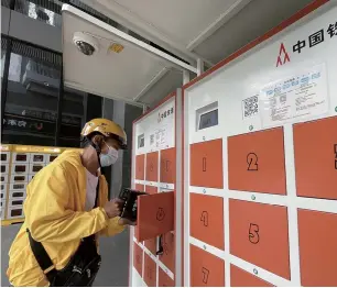  ?? ?? A delivery rider swaps his e-bike battery at a smart exchange and charging cabinet in Shenzhen, south China’s Guangdong Province. — IC