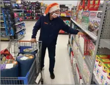  ?? PHOTO PROVIDED ?? Dunkin’ field marketing manager Eric Stensland selects board games during the Toys for Tots shopping spree on Tuesday at Walmart in Albany. The $30,000Dunkin’ shopping spree will supply hundreds of toys for children in need and is a continuati­on of support fromCapita­l Region franchisee­s during a holiday season challenged by the global health pandemic.