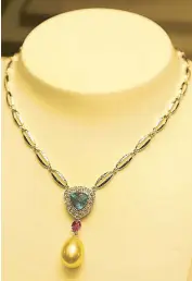  ??  ?? Riviera: A playful combinatio­n of pink sapphire, blue apatite, and golden South Sea pearl with white gold cowrie shell necklace