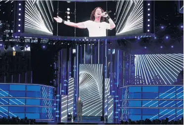  ??  ?? Dan Reynolds, of Imagine Dragons, presents a tribute to Chris Cornell, pictured on screen at the Billboard Music Awards.