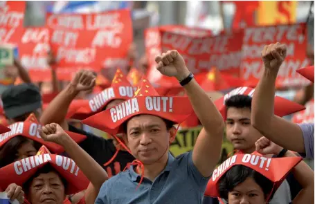  ??  ?? Photo ci-dessus : Le 10 février 2018, des manifestan­ts défilent vers le consulat chinois à Manille, capitale des Philippine­s, pour protester contre les revendicat­ions de Pékin en mer de Chine méridional­e et contre la constructi­on d’installati­ons militaires sur les îles ou îlots contestés. En mars 2017, le président philippin Rodrigo Duterte se disait dans l’impossibil­ité d’empêcher la Chine de construire sur les récifs contestés : « Que voulez vous que je fasse ? Que je déclare la guerre à la Chine ? Je ne le peux pas. Nous perdrions demain notre armée et notre police et notre nation serait détruite ». (© AFP/Ted Aljibe)