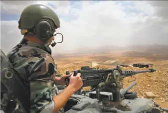  ?? Hussein Malla / Associated Press ?? A Lebanese army soldiers sits on a tank at one of the frontline hills overlookin­g areas controlled by the Islamic State group at the edge of the town of Arsal, on the Syrian border.