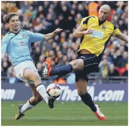  ?? ?? FLASHBACK Lee Molyneaux, above left, playing for Gosport against Camrbridge United in the 2014 FA Trophy final. Above right - Harry Sargeant (blue) keeping a close eye on James Franklyn during last August’s Wessex League derby at Baffins’ PMC Stadium