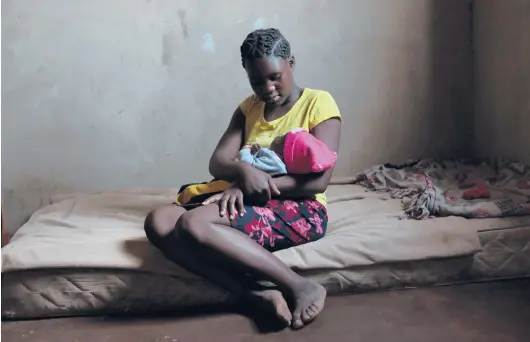  ?? TSVANGIRAY­I MUKWAZHI/AP PHOTOS 2021 ?? Virginia Mavhunga, 13, dropped out of school after becoming pregnant. She holds her child in her rural home in Murehwa, Zimbabwe.