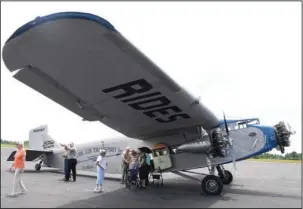  ?? The Sentinel-Record/Grace Brown ?? TOURING: Visitors from West Shores Senior Living exit a 1929 Ford Tri-Motor airplane following a tour given on Thursday. Free tours are open to the public between flights until the aircraft leaves on Sunday.
