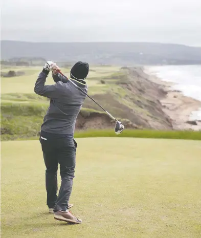  ?? PHOTOS: ANDREW VAUGHAN / THE CANADIAN PRESS ?? A golfer hits from the tee on the 528-yard, par 5, 18th hole at Cabot Cliffs, the seaside course in Inverness.