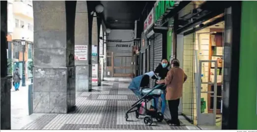  ?? RAFA DEL BARRIO ?? Dos ciudadanos a las puertas de una farmacia en el centro de la capital onubense.