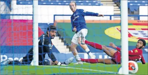  ??  ?? Tom Davies remata un balón que estrelló al palo derecho de Alisson en el empate entre Everton y Liverpool ayer en Goodison Park.